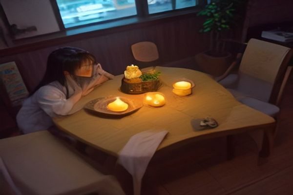 约会场景中女性穿着黑色超薄丝袜搭配8cm细跟高跟鞋坐在咖啡馆，腿型修长优雅，暖光氛围